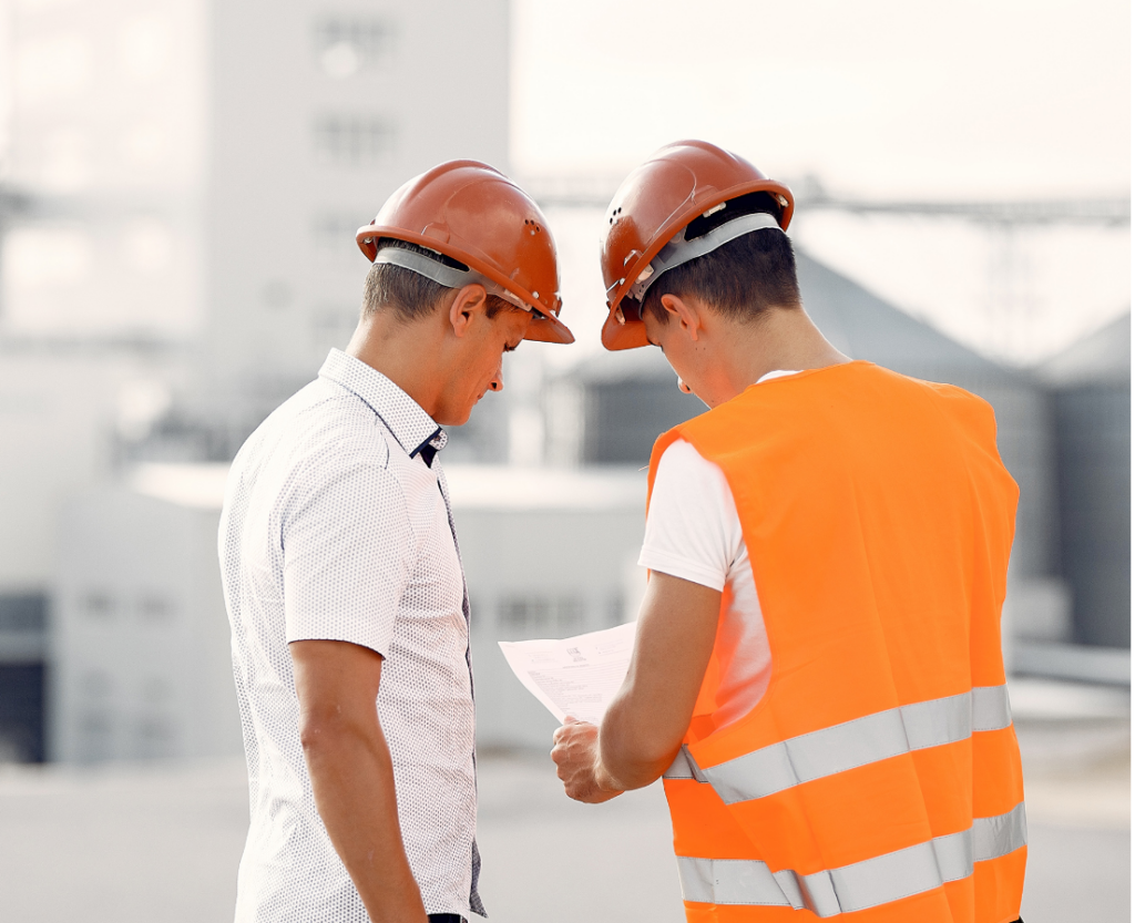 Deux ouvriers avec des casques de chantier et un gilet de sécurité