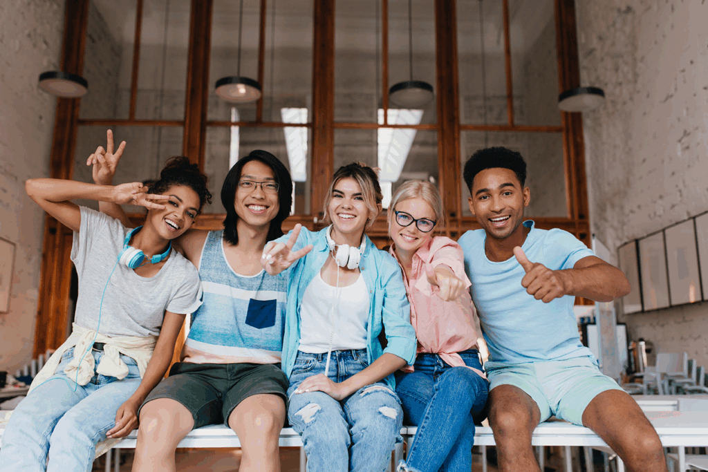 étudiants souriants assis sur une table